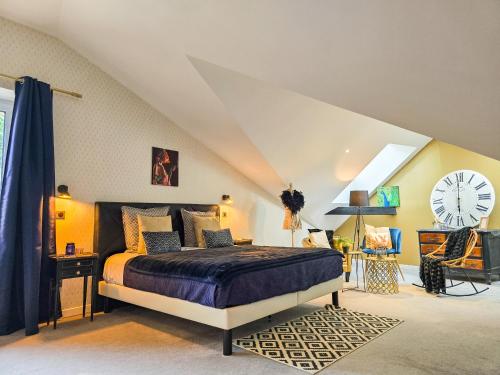 a bedroom with a bed and a clock on the wall at La Fraizière in Arnaville