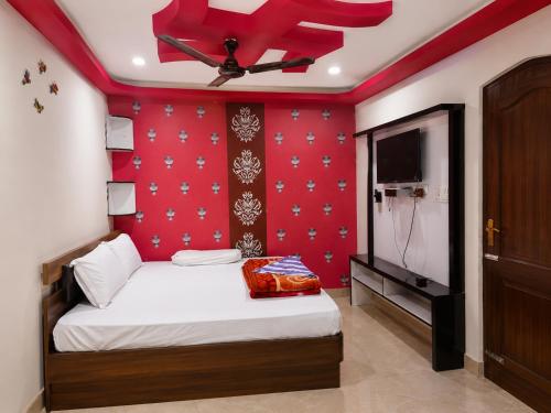 a bedroom with a bed with a red wall at Dooars View Hotel in Hāsimāra