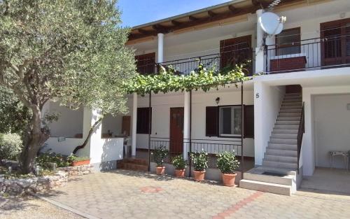 a house with a staircase in front of it at Apartmani Sekana in Starigrad