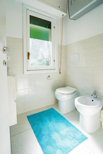 a bathroom with a white toilet and a blue rug at Moneglia - Le Case di Bart in Moneglia