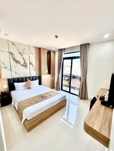 a bedroom with a large bed and a large window at Khách Sạn Anh Khoa 2 in Phan Rang–Tháp Chàm