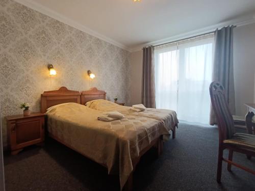a bedroom with a large bed and a window at Dworek Bursztynowy in Karwia