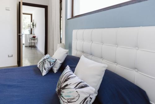 a bedroom with a bed with blue sheets and pillows at Villa Serra d'Elci in Ascea