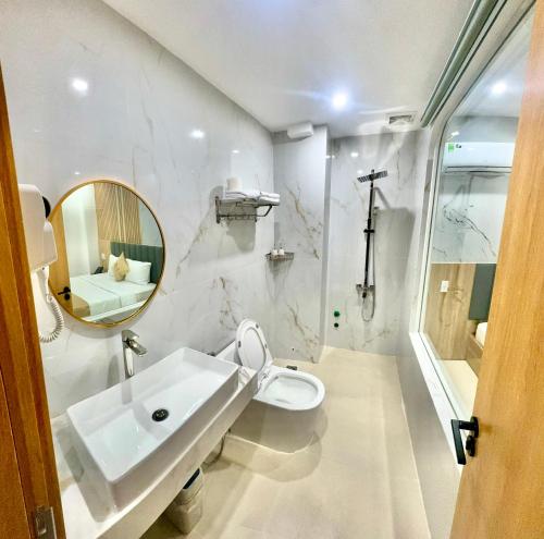 a bathroom with a sink and a toilet and a mirror at Khách Sạn Anh Khoa 2 in Phan Rang–Tháp Chàm