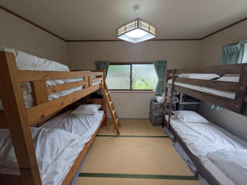 two bunk beds in a room with a window at 平屋宿まえの in Motoyama