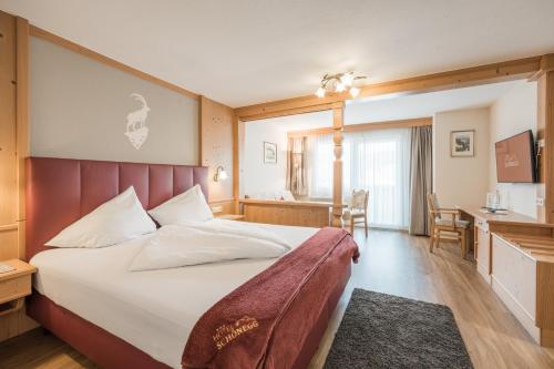 a hotel room with a bed and a desk at Hotel Schönegg in Seefeld in Tirol