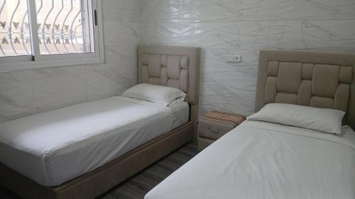 a bedroom with two beds and a window at Palm Serenity in Tangier