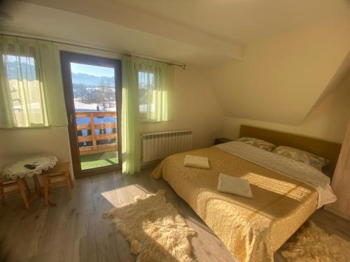 a bedroom with two beds and a large window at Kapacówka in Zakopane