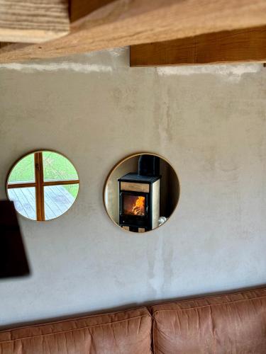 two circular windows on a wall with a fireplace at Studio MEZILES in Buš