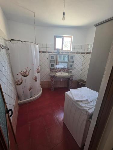 a bathroom with a bed and a tub in a room at Comfort Saranda Apartment in Sarandë
