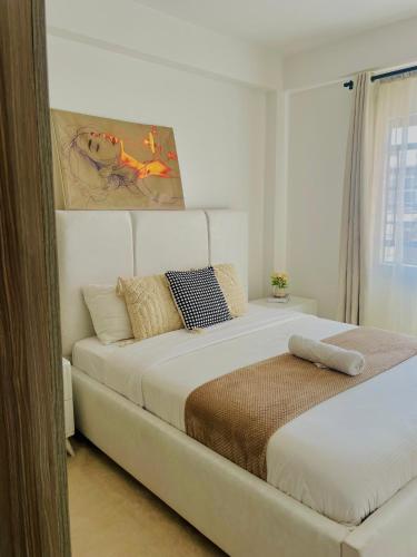 a bedroom with a large white bed with pillows at Bethany Cushy Home Ltd in Kisii