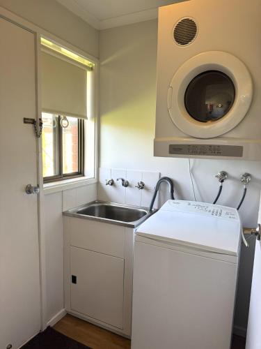 a small kitchen with a sink and a microwave at Barwon Valley Lodge in Geelong
