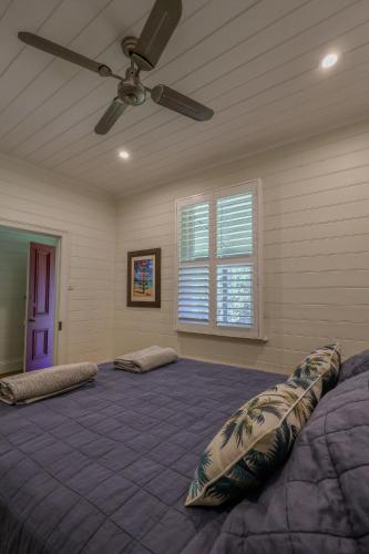 a bedroom with a large bed with a ceiling fan at Handleys Cottage in High Range