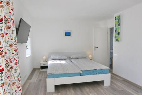 een witte slaapkamer met een bed in een kamer bij CastleView in Ljubljana