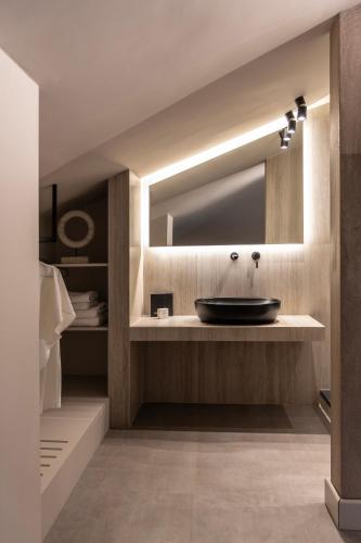 a bathroom with a sink and a mirror at Nikoleta Hotel and Villas in Limenas