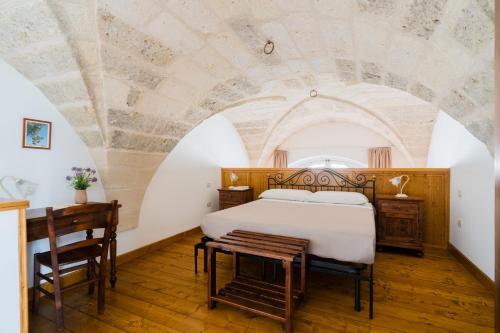 a bedroom with a bed and a table at Tre Volte Belle - Salento Selection in Carpignano Salentino
