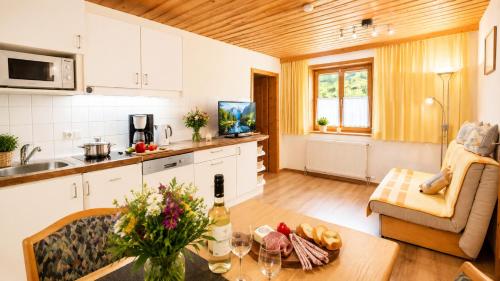 a kitchen and living room with a table with flowers on it at Ferienwohnung in Itter bei Söll SkiWelt Wilder Kaiser Kitzbüheler Alpen ITD100 in Itter
