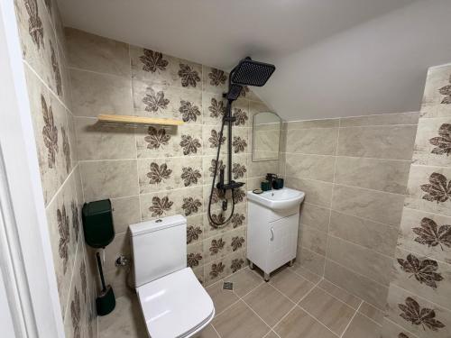 a bathroom with a white toilet and a shower at Eleonor Guest House in Byala