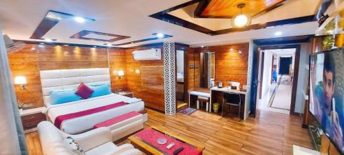 a living room with a white bed and a desk at Hotel Rodali Residency in Guwahati