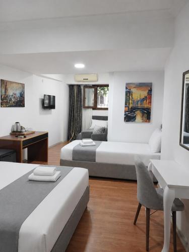 a hotel room with two beds and a desk at Hotel Efesian B&B City Center - Harbour in Kuşadası