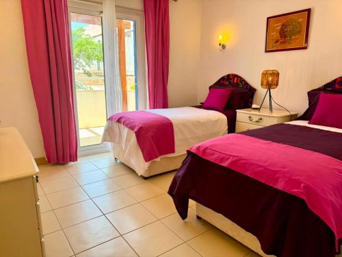 a hotel room with two beds and a window at Santa Maria Ilha do Sal T2 Apartament with pool A&L em Vila Verde in Prainha