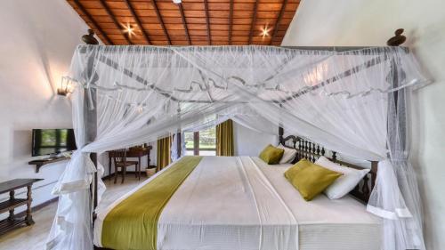 a bedroom with a bed with a canopy at Leaf Watagala in Avissawella