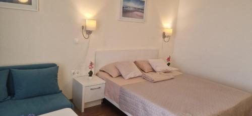 a small bedroom with a bed and a blue chair at Adela Sunset View by Blaxy Resort in Olimp