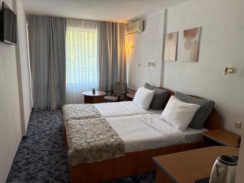 a hotel room with a bed and a chair at Kamchia Park Hotel - All Inclusive in Golden Sands