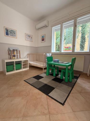 a living room with a green table and chairs at 7Csakra Vendeghaz in Szentendre