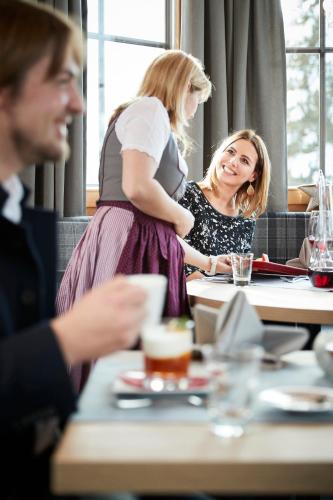 two women sitting at a table in a restaurant at Der Postwirt in Söll