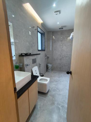 a bathroom with a white toilet and a sink at G RAK HOTELs in Etah