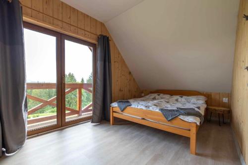 a bedroom with a bed and a large window at Chata Michala in Dolný Kubín