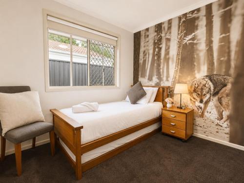 a bedroom with a bed and a dog picture on the wall at Pet Friendly close to Mooloolaba Sleeps 6 in Mountain Creek