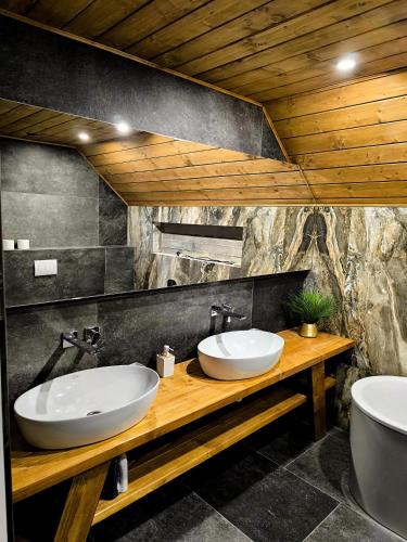 two sinks on a wooden counter in a bathroom at Chalet Martinky in Martin