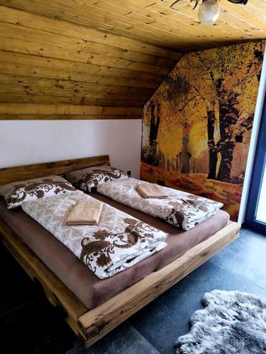 two beds in a room with a painting on the wall at Chalet Martinky in Martin