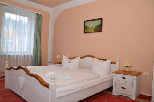ein Schlafzimmer mit einem weißen Bett und einem Fenster in der Unterkunft Hotel Central in Bad Elster
