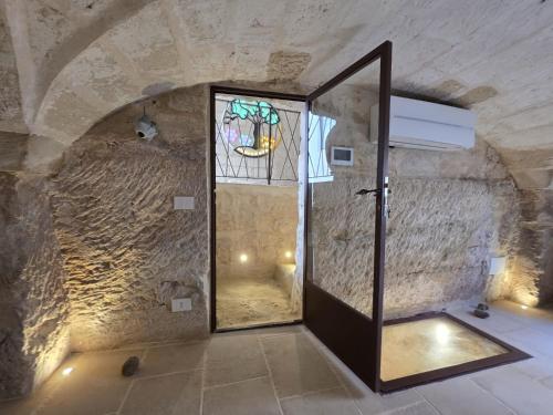 a room with a door in a stone wall at Dimora Pietra E Luce By Cala Salento in Vignacastrisi