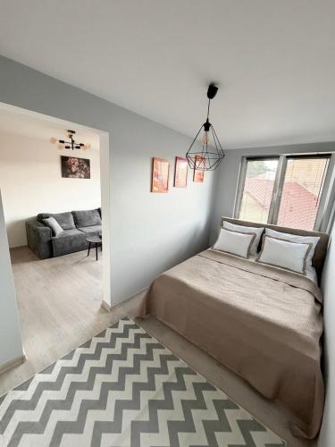 a bedroom with a bed and a living room at Apartament Staropijarska in Łuków