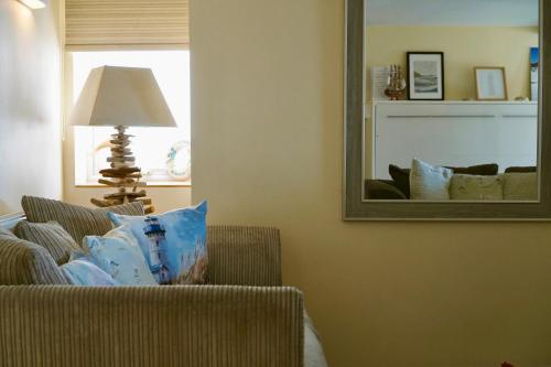 a living room with a chair and a mirror at Superb Cintra Beachside Apartments in Llandudno