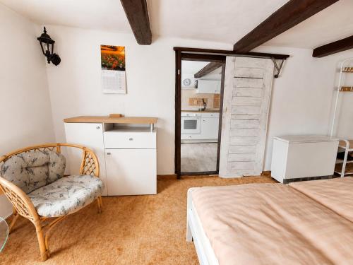 a bedroom with a bed and a chair and a door at Apartmán Domeček u parku in Česká Lípa