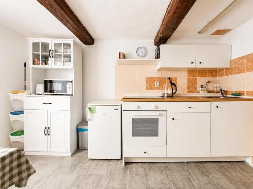 a white kitchen with white cabinets and appliances at Apartmán Domeček u parku in Česká Lípa