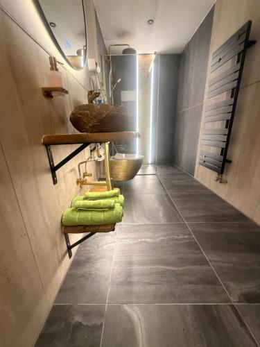 a bathroom with green towels on a tile floor at Emerald Alpine Apartment Seefeld in Seefeld in Tirol