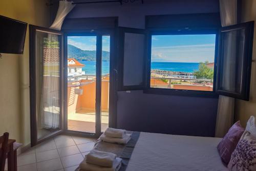 a bedroom with a bed and a view of the ocean at Lavender Apartments in Skala Potamias