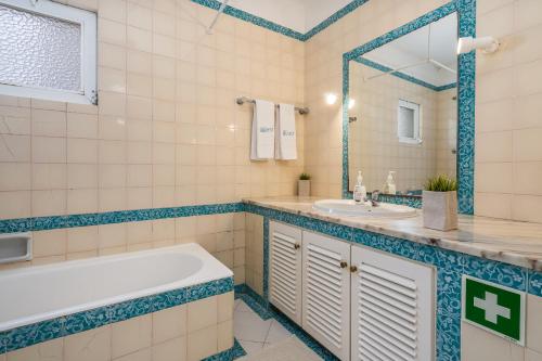 a bathroom with a tub and a sink at Prainha Lounge in Alvor