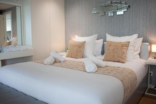 a bedroom with a large white bed with pillows at Luxury by the Blue in Vila Nova de Gaia