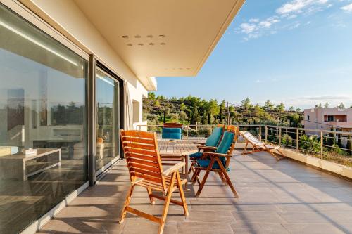 a patio with chairs and a table on a balcony at White Sand Loutraki Villa - Sea View in Loutraki
