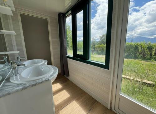 a bathroom with two sinks and a large window at T4 avec jardin - ENVEITG in Enveitg