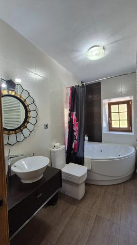 a bathroom with a large tub and a toilet and a sink at Islabeach in Isla
