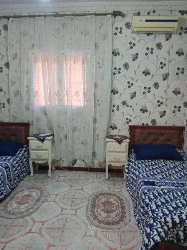 a bedroom with two beds and a window at Oran ville in Oran
