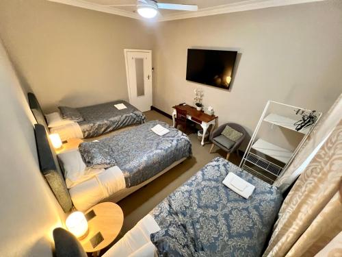 a hotel room with two beds and a television at Bõucher Manor - Northam in Northam